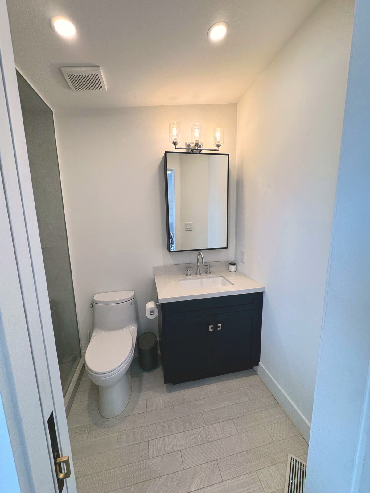 Ensuite powder bath with navy custom vanity