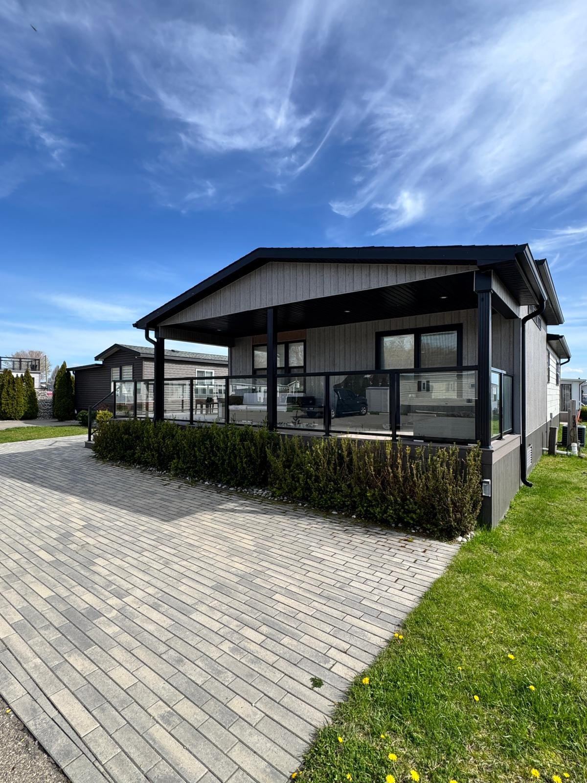 Cottage exterior with wrap-around composite deck and glass railings